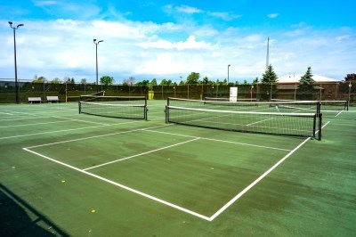 green pickleball courts under a blue sky